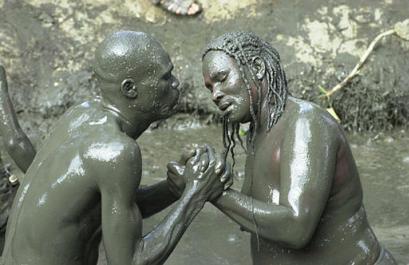 Hatians possessed by Voodoo spirits bathe in sacred mud pool